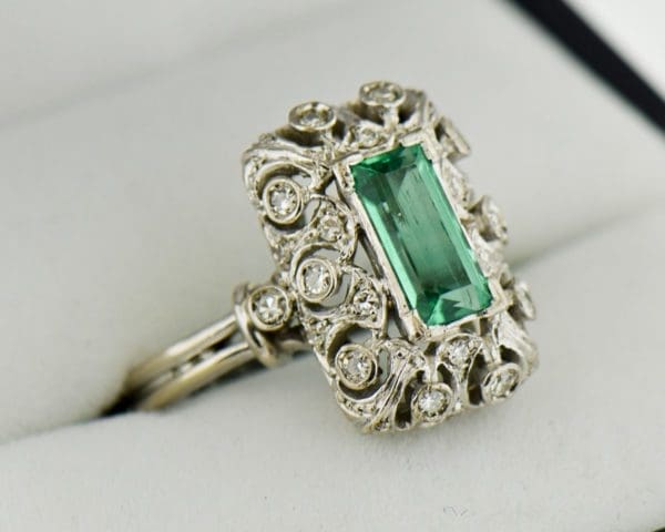 vintage platinum ring with filigree diamonds and elongated emerald