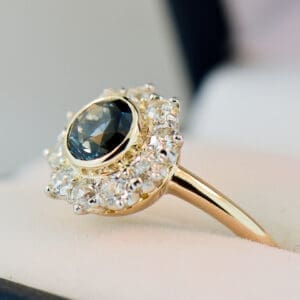 antique yellow gold halo engagement ring set with teal sapphire and diamonds