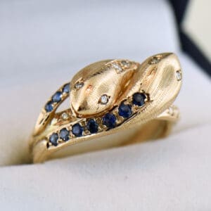 vintage two headed rose gold snake ring set with sapphires
