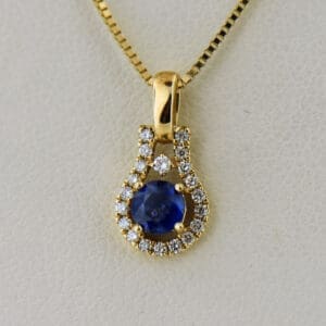 dainty blue sapphire and diamond pendant in yellow gold