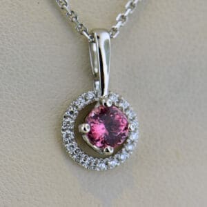 round pink spinel and diamond halo pendant
