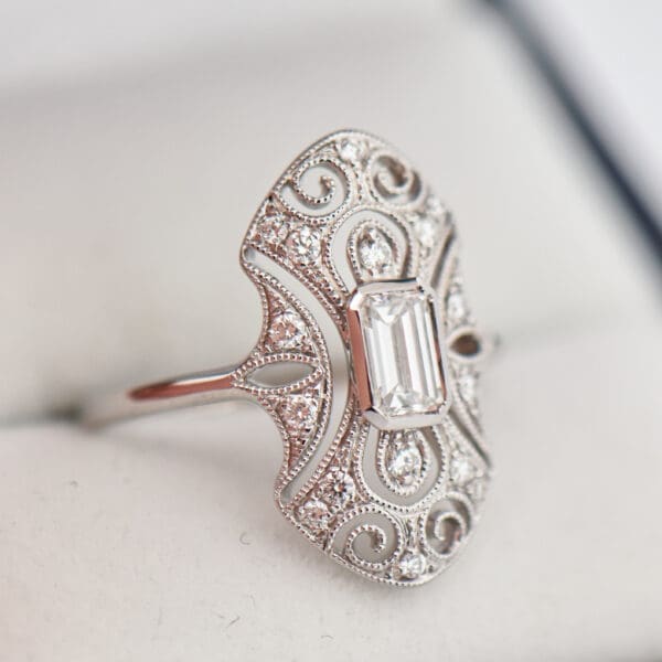 art deco style ring with emerald cut diamond and filigree 3