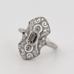 art deco style ring with emerald cut diamond and filigree