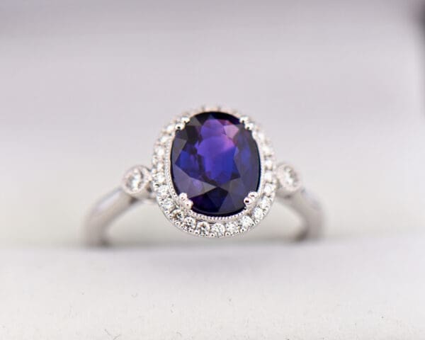 oval halo engagement ring with rare blue purple sapphire