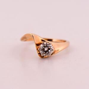 mid century curved gold engagement ring with half carat diamond