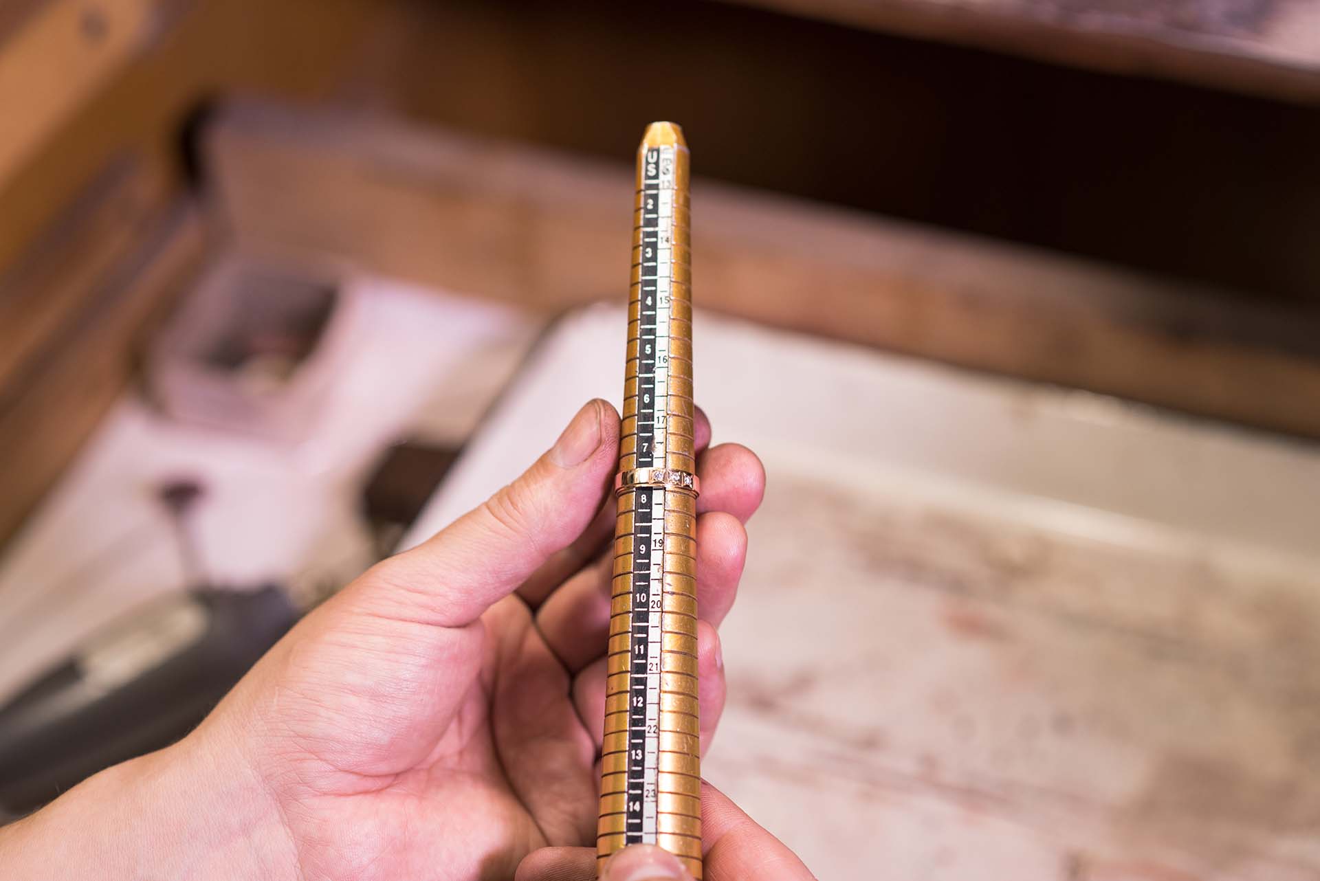 Male hands of a jeweler who measures the size of a ring using a ring gauge
